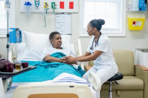 Person in bed with doctor at the bedside